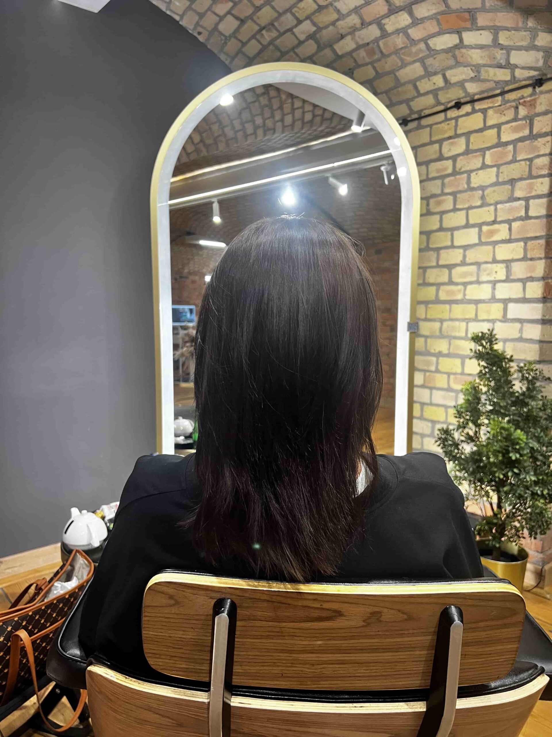 Przedłużanie włosów naturalnych czarnych – efekt przed zabiegiem, włosy proste o średniej długości.